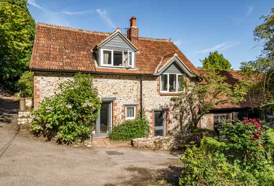 Halshayne Cottage, a stone cottage with dormer windows and a tiled roof.