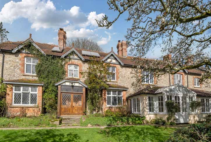 The south front of the house, stone with brick dressings, bay windows and climbing plants.
