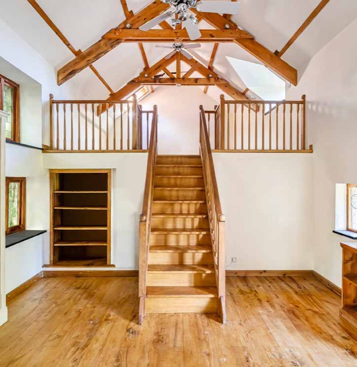 The Winter Study with exposed trusses and a staircase to the mezzanine.