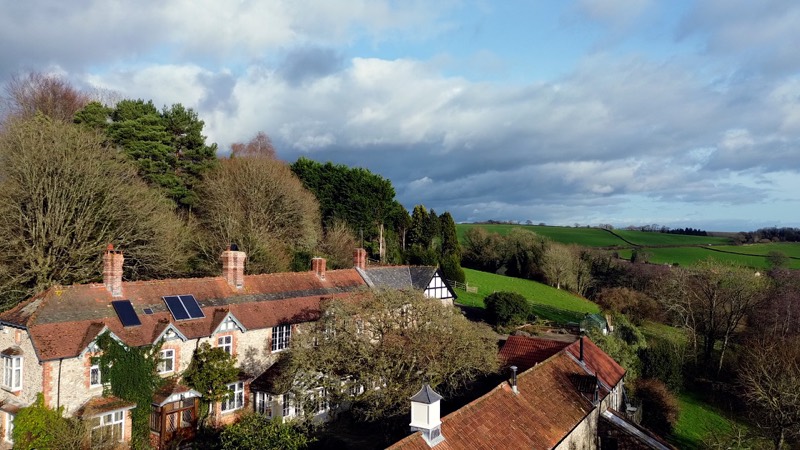 A low pass over the roofs, showing tiling, brick chimneys and solar panels.