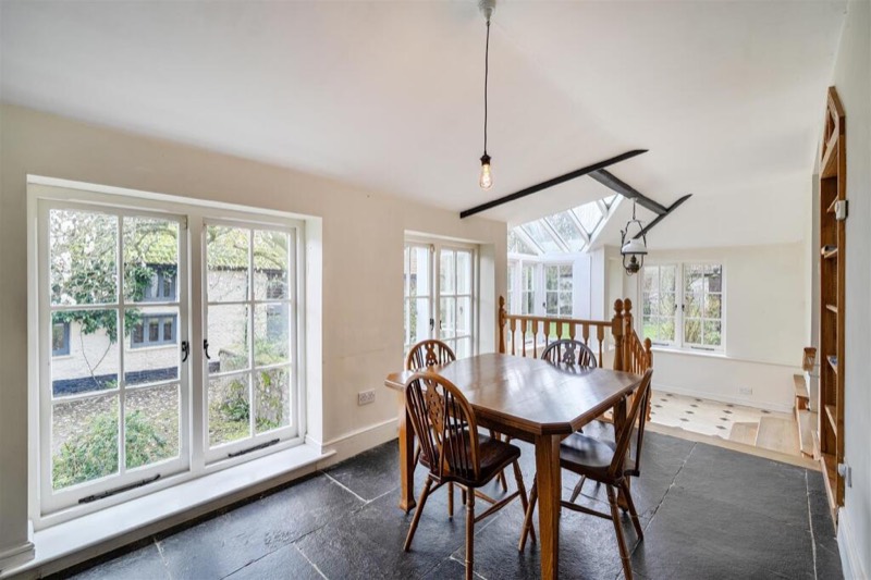 The breakfast room with a slate floor and tall garden windows.