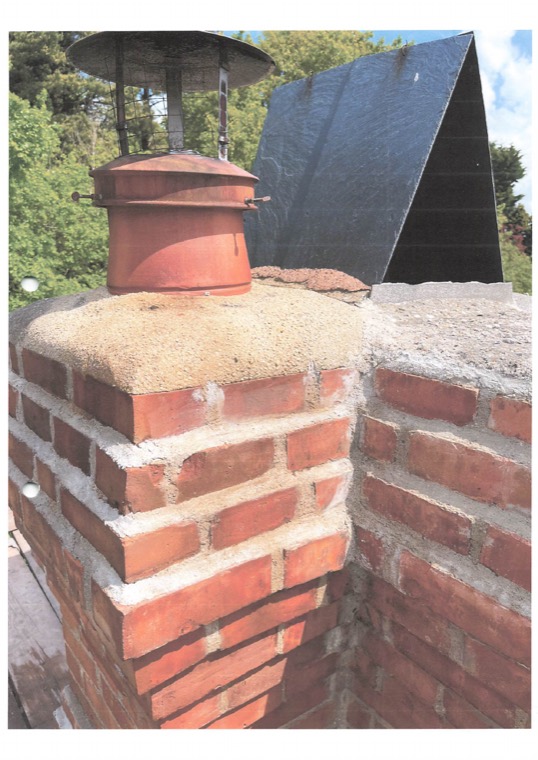 A finished stack with new brickwork, a rendered flaunching, a clay pot and a wire rain cowl.
