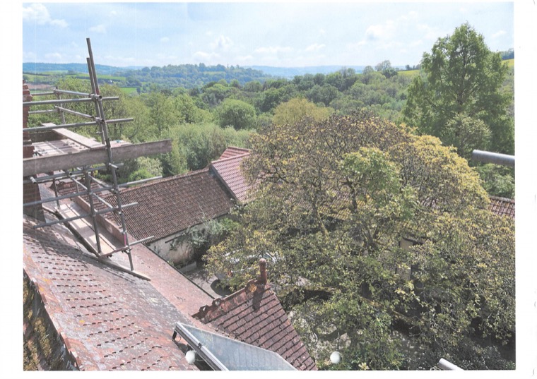View from the scaffolding over the barn roofs and the courtyard trees to the valley beyond.