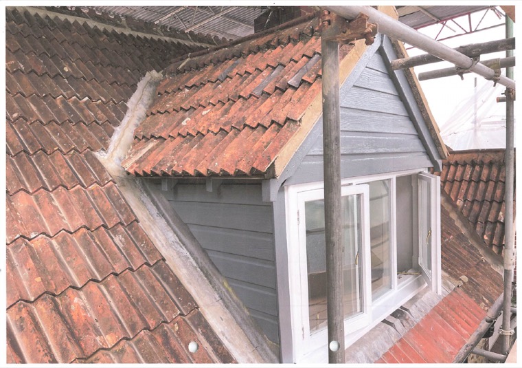 A dormer under repair, its cheeks reclad and the tiles stripped back around it.