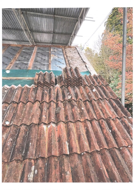 Insulation boards fixed over the rafters with battens above, and reclaimed tiles being re-laid up the slope.